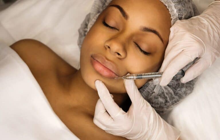 visage d'une femme recevant une injection d'acide hyaluronique par un dermatologue
