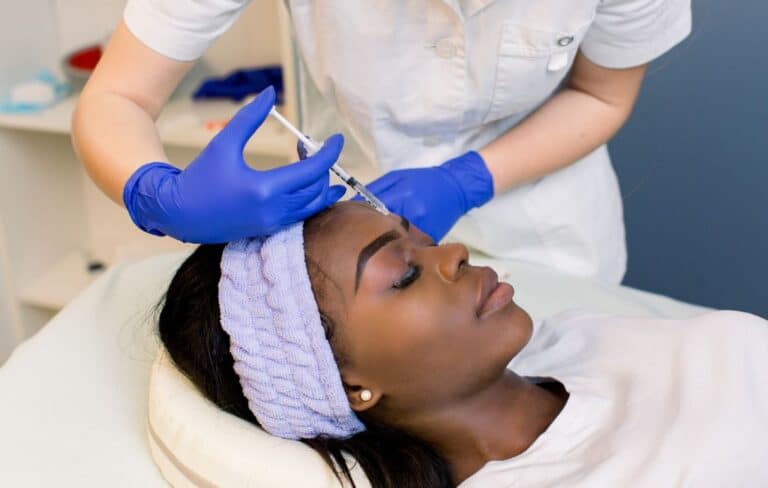 visage d'une femme recevant une injection de toxine botulique par un dermatologue